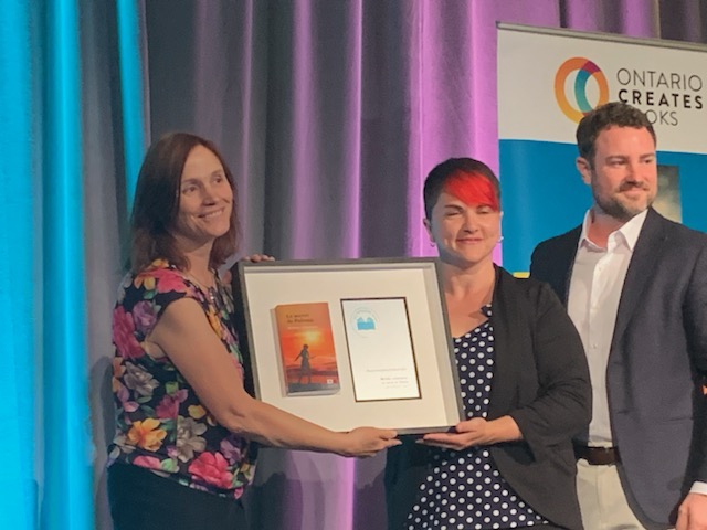 Michèle en blouse fleurie recevant son beau prix! Avec la représentante de sa maison d'éditiont qui a les yeux fermés... (Photo Gilles Gagnon)

