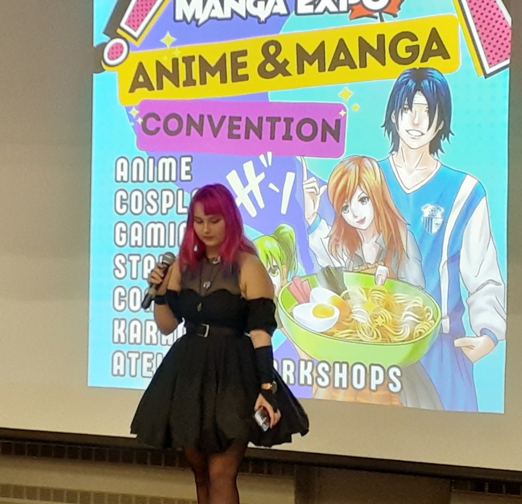 Une jeune chanteuse en cosplay. Derrière elle, une illustration de Manga